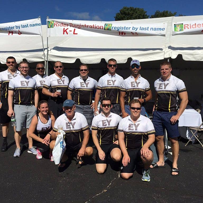 Large group of cyclists posing for a photo with EY jerseys on.