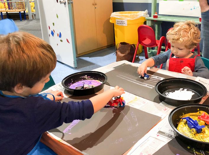 Children painting with toy cars as brushes