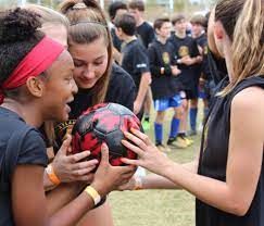 Three girls holding a soccer ball