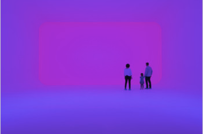 Museum patrons admiring a neon light exhibit